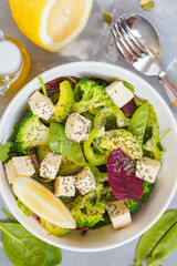 Healthy green salad with broccoli, tofu, avocado, peas and chia seeds. Top view.