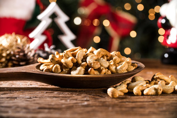 cashew nuts in a bowl on the board with blurred christmas background