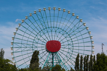 Fototapeta premium Ferris Wheel with White Cabins againt Blue Sky