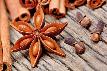 Anise star with cinnamon sticks and cloves on rustic wooden table