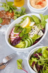 Green salad, buddha bowl with tofu, vegetables, hummus with flax crispbread.