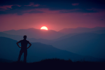 Silhouette of human standing on a hill