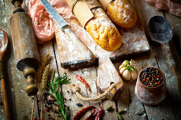 Bread and pastries in a composition with kitchen accessories on an old background