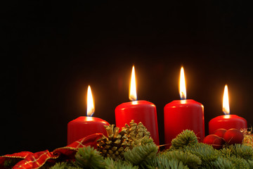 Red candles of an Advent wreath with fir branches