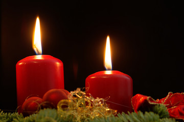 Red candles of an Advent wreath with fir branches