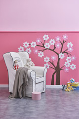 modern room pink wall and decorative modern chair style with blanket and baby toys