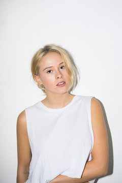 Blonde woman posing at white wall