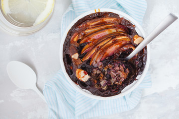 Vegan baked oatmeal crumble with apple, blueberry, Brazil nut and date syrup, top view