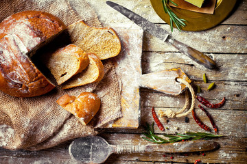 Bread and pastries in a composition with kitchen accessories on an old background