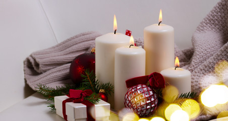 White glowing advent candles with christmas decorations banner