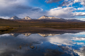 Fototapeta na wymiar The mountain range Munku-Sardyk is reflected in the lake water
