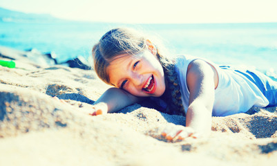blond child lying on sandy beach of sea coast © caftor