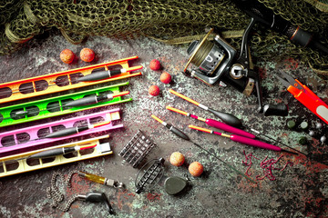 Fishing rods and spinnings in the composition with accessories for fishing on the old background on the table