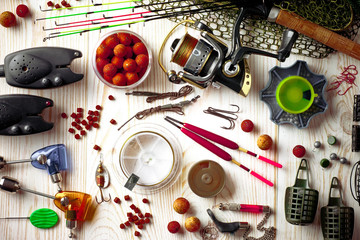 Fishing rods and spinnings in the composition with accessories for fishing on the old background on the table