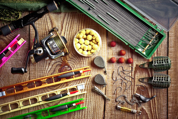 Fishing rods and spinnings in the composition with accessories for fishing on the old background on the table
