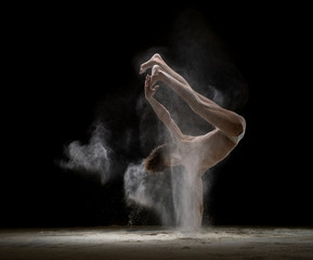 Plakat Man doing handstand in a white dust cloud view
