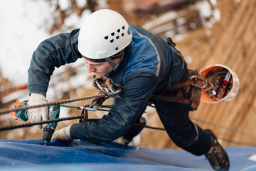 Professional industrial climber in helmet and uniform works at height. Risky extreme job....