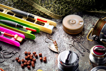 Fishing rods and spinnings in the composition with accessories for fishing on the old background on the table