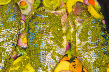 fresh uncooked spiced tilapia fish
