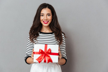 Fototapeta premium Portrait of a smiling girl holding present box