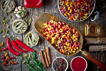 Raw pasta in the composition on the table with items for cooking