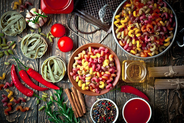 Raw pasta in the composition on the table with items for cooking