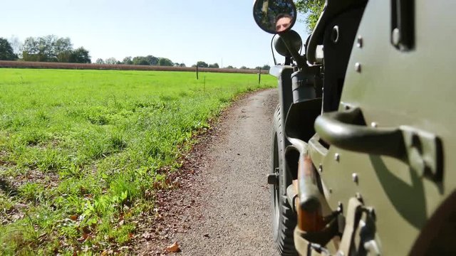 military 4x4 car driving on dirt road