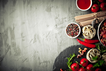 Raw pasta in the composition on the table with items for cooking