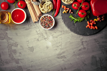 Raw pasta in the composition on the table with items for cooking