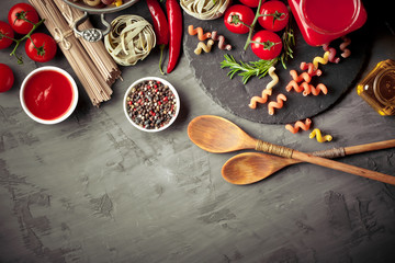Raw pasta in the composition on the table with items for cooking