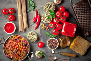 Raw pasta in the composition on the table with items for cooking