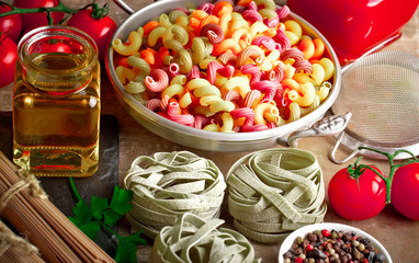 Raw pasta in the composition on the table with items for cooking