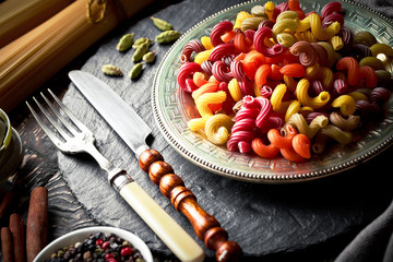 Raw pasta in the composition on the table with items for cooking