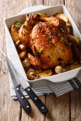 Tasty food: grilled chicken with mushrooms and potatoes close-up in a baking dish. Vertical © FomaA