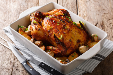 Beautiful crispy grilled chicken with mushrooms and potatoes close-up in a baking dish. horizontal © FomaA