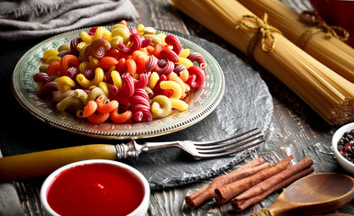 Raw pasta in the composition on the table with items for cooking