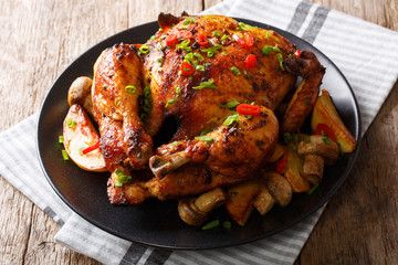 Grilled food: chicken with mushrooms and potatoes close-up on a plate. horizontal