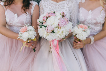 Bride and your girlfriends in pink dress with bouquets on the wedding.