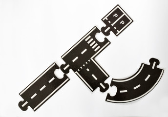 Puzzle road way pieces on a white empty background with marking stripes and direction
