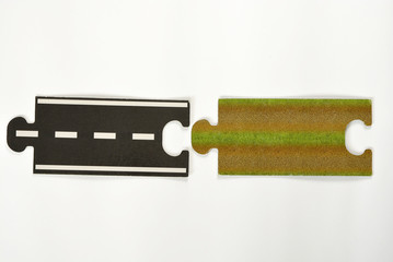 Puzzle road way pieces on a white empty background with marking stripes and direction