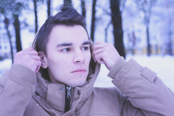 A young man walks in the woods in winter. Cold, frost, snow, winter.