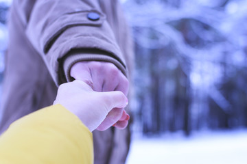 A young man and a girl are walking through the woods in the winter. Cold, frost, snow, winter.