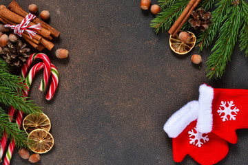 Christmas tree with decorations and mittens on a brown background with space under the text.