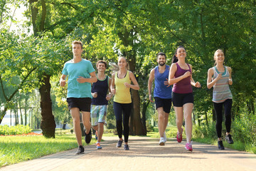 Group of young people running in park