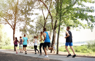 Fototapeta premium Group of young people running in park