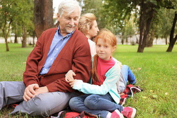 Naklejka na ściany i meble Happy senior couple with granddaughter in park