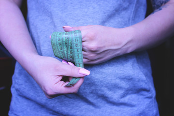 A girl holds a centimeter in his hands. The concept of weight loss. Struggle with weight.
