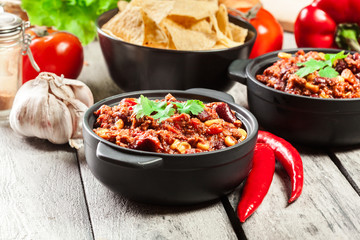 Bowls of hot chili con carne with ground beef, beans, tomatoes and corn