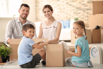 Happy family unpacking things in new flat