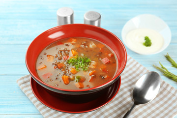 Dish with tasty lentil soup on table